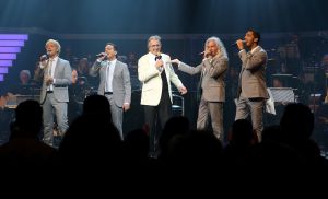 26-04-2013 SHOWBIZZ; GORDON NU OOK PROBLEMEN MET ZIJN VOICES. Gordon is van mening dat hij geen absurde eisen stelt aan zijn ex-collega s van LA The Voices. Ik heb de naam verzonnen, ik heb alles opgebouwd.
Donderdagavond werd bekend dat Gorden en de overige vier zangers van de groep behoorlijke ruzie over geld hebben sinds Gordon besloten heeft ermee te stoppen. Ze hebben zelfs advocaten in de arm genomen om het uit te vechten. Die jongens moeten gewoon een bedrag betalen per optreden of per gekochte cd, vindt Gordon. Dat is volkomen normaal.

De andere Voices zijn het hier volledig mee oneens. Hij kan niet vanuit Blaricum met een afstandsbediening het schip blijven besturen, zegt Peter Strykes, een van hen. Ik dacht dat de slavernij al heel lang geleden was afgeschaft. Toch hoopt Strykes dat ze er nog zonder advocaat uit kunnen komen. Ik houd niet van moddergooien.
Afgelopen week had Gordon ook al een hevige ruzie met Mark v.d.Linden.
The Voices waren 3 dagen te gast in de theater show van Lee Towers in het Nieuwe Luxor te Rotterdam, wat een daverend succes was.
foto: Albert den Iseger.