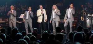 26-04-2013 SHOWBIZZ; GORDON NU OOK PROBLEMEN MET ZIJN VOICES. Gordon is van mening dat hij geen absurde eisen stelt aan zijn ex-collega s van LA The Voices. Ik heb de naam verzonnen, ik heb alles opgebouwd.
Donderdagavond werd bekend dat Gorden en de overige vier zangers van de groep behoorlijke ruzie over geld hebben sinds Gordon besloten heeft ermee te stoppen. Ze hebben zelfs advocaten in de arm genomen om het uit te vechten. Die jongens moeten gewoon een bedrag betalen per optreden of per gekochte cd, vindt Gordon. Dat is volkomen normaal.

De andere Voices zijn het hier volledig mee oneens. Hij kan niet vanuit Blaricum met een afstandsbediening het schip blijven besturen, zegt Peter Strykes, een van hen. Ik dacht dat de slavernij al heel lang geleden was afgeschaft. Toch hoopt Strykes dat ze er nog zonder advocaat uit kunnen komen. Ik houd niet van moddergooien.
Afgelopen week had Gordon ook al een hevige ruzie met Mark v.d.Linden.
The Voices waren 3 dagen te gast in de theater show van Lee Towers in het Nieuwe Luxor te Rotterdam, wat een daverend succes was.
foto: Albert den Iseger.