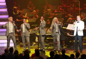 26-04-2013 SHOWBIZZ; GORDON NU OOK PROBLEMEN MET ZIJN VOICES. Gordon is van mening dat hij geen absurde eisen stelt aan zijn ex-collega s van LA The Voices. Ik heb de naam verzonnen, ik heb alles opgebouwd.
Donderdagavond werd bekend dat Gorden en de overige vier zangers van de groep behoorlijke ruzie over geld hebben sinds Gordon besloten heeft ermee te stoppen. Ze hebben zelfs advocaten in de arm genomen om het uit te vechten. Die jongens moeten gewoon een bedrag betalen per optreden of per gekochte cd, vindt Gordon. Dat is volkomen normaal.

De andere Voices zijn het hier volledig mee oneens. Hij kan niet vanuit Blaricum met een afstandsbediening het schip blijven besturen, zegt Peter Strykes, een van hen. Ik dacht dat de slavernij al heel lang geleden was afgeschaft. Toch hoopt Strykes dat ze er nog zonder advocaat uit kunnen komen. Ik houd niet van moddergooien.
Afgelopen week had Gordon ook al een hevige ruzie met Mark v.d.Linden.
The Voices waren 3 dagen te gast in de theater show van Lee Towers in het Nieuwe Luxor te Rotterdam, wat een daverend succes was.
foto: Albert den Iseger.