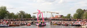 06-08-2009 SHOWBIZZ; GAY PRIDE AMSTERDAM TREKT MEER DAN 600.000 BEZOEKERS. Een giga festijn de 2009 Gay Pride in Amsterdam, duizenden bootjes, honderdduizenden bezoekers en een Sinterklaas die na het uur moest worden opgenomen met wel heel vreemde verschijnselen, en als wij de media moeten geloven na het drinken van een wodkaatje. Wij weten beter want wij waren er smorgens vroeg al bij,plaats van alle verrassingen De Westerdok haven.Toen was het nog niet heet, er waaide een heerlijk windje en de aanwezige BNers hadden er zin in, zelfs Sint Nicolaas of te wel Gordon. Menig drankje gleed naar binnen voordat de boten vertrokken richting de Prinsengracht. Als dat maar goed gaat dacht ik nog. En het ging niet goed, Sint Nicolaas werd witter dan wit en werd lieftallig verzorgd door de dames met ijsklontjes. Niks hitte beroerte of een schommelende boot, zware mijter of Sinterklaaspak van velours. Gordon droeg een wit katoenen pantalon en een katoenen hemt met inderdaad een mantel die helemaal los hing. Niks bevangen door de hitte, andere oorzaken dwongen hem tot stoppen van de Stoompoot boot. Sinterklaas werd afgevoerd in een ambulance voor verder onderzoek. Zondag avond was Gordon weer van de partij om de Gay Pride party te besluiten met een optreden. Al met al weer een zeer bewogen weekend voor vele mensen.
foto: Albert den Iseger