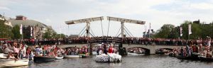 06-08-2009 SHOWBIZZ; GAY PRIDE AMSTERDAM TREKT MEER DAN 600.000 BEZOEKERS. Een giga festijn de 2009 Gay Pride in Amsterdam, duizenden bootjes, honderdduizenden bezoekers en een Sinterklaas die na het uur moest worden opgenomen met wel heel vreemde verschijnselen, en als wij de media moeten geloven na het drinken van een wodkaatje. Wij weten beter want wij waren er smorgens vroeg al bij,plaats van alle verrassingen De Westerdok haven.Toen was het nog niet heet, er waaide een heerlijk windje en de aanwezige BNers hadden er zin in, zelfs Sint Nicolaas of te wel Gordon. Menig drankje gleed naar binnen voordat de boten vertrokken richting de Prinsengracht. Als dat maar goed gaat dacht ik nog. En het ging niet goed, Sint Nicolaas werd witter dan wit en werd lieftallig verzorgd door de dames met ijsklontjes. Niks hitte beroerte of een schommelende boot, zware mijter of Sinterklaaspak van velours. Gordon droeg een wit katoenen pantalon en een katoenen hemt met inderdaad een mantel die helemaal los hing. Niks bevangen door de hitte, andere oorzaken dwongen hem tot stoppen van de Stoompoot boot. Sinterklaas werd afgevoerd in een ambulance voor verder onderzoek. Zondag avond was Gordon weer van de partij om de Gay Pride party te besluiten met een optreden. Al met al weer een zeer bewogen weekend voor vele mensen.
foto: Albert den Iseger