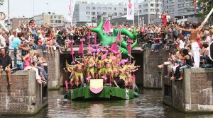 06-08-2009 SHOWBIZZ; GAY PRIDE AMSTERDAM TREKT MEER DAN 600.000 BEZOEKERS. Een giga festijn de 2009 Gay Pride in Amsterdam, duizenden bootjes, honderdduizenden bezoekers en een Sinterklaas die na het uur moest worden opgenomen met wel heel vreemde verschijnselen, en als wij de media moeten geloven na het drinken van een wodkaatje. Wij weten beter want wij waren er smorgens vroeg al bij,plaats van alle verrassingen De Westerdok haven.Toen was het nog niet heet, er waaide een heerlijk windje en de aanwezige BNers hadden er zin in, zelfs Sint Nicolaas of te wel Gordon. Menig drankje gleed naar binnen voordat de boten vertrokken richting de Prinsengracht. Als dat maar goed gaat dacht ik nog. En het ging niet goed, Sint Nicolaas werd witter dan wit en werd lieftallig verzorgd door de dames met ijsklontjes. Niks hitte beroerte of een schommelende boot, zware mijter of Sinterklaaspak van velours. Gordon droeg een wit katoenen pantalon en een katoenen hemt met inderdaad een mantel die helemaal los hing. Niks bevangen door de hitte, andere oorzaken dwongen hem tot stoppen van de Stoompoot boot. Sinterklaas werd afgevoerd in een ambulance voor verder onderzoek. Zondag avond was Gordon weer van de partij om de Gay Pride party te besluiten met een optreden. Al met al weer een zeer bewogen weekend voor vele mensen.
foto: Albert den Iseger