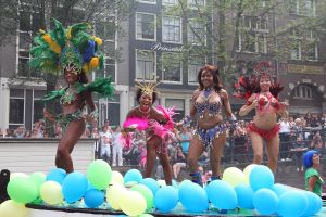 06-08-2009 SHOWBIZZ; GAY PRIDE AMSTERDAM TREKT MEER DAN 600.000 BEZOEKERS. Een giga festijn de 2009 Gay Pride in Amsterdam, duizenden bootjes, honderdduizenden bezoekers en een Sinterklaas die na het uur moest worden opgenomen met wel heel vreemde verschijnselen, en als wij de media moeten geloven na het drinken van een wodkaatje. Wij weten beter want wij waren er smorgens vroeg al bij,plaats van alle verrassingen De Westerdok haven.Toen was het nog niet heet, er waaide een heerlijk windje en de aanwezige BNers hadden er zin in, zelfs Sint Nicolaas of te wel Gordon. Menig drankje gleed naar binnen voordat de boten vertrokken richting de Prinsengracht. Als dat maar goed gaat dacht ik nog. En het ging niet goed, Sint Nicolaas werd witter dan wit en werd lieftallig verzorgd door de dames met ijsklontjes. Niks hitte beroerte of een schommelende boot, zware mijter of Sinterklaaspak van velours. Gordon droeg een wit katoenen pantalon en een katoenen hemt met inderdaad een mantel die helemaal los hing. Niks bevangen door de hitte, andere oorzaken dwongen hem tot stoppen van de Stoompoot boot. Sinterklaas werd afgevoerd in een ambulance voor verder onderzoek. Zondag avond was Gordon weer van de partij om de Gay Pride party te besluiten met een optreden. Al met al weer een zeer bewogen weekend voor vele mensen.
foto: Albert den Iseger