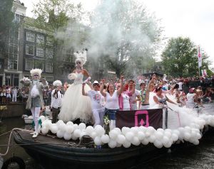 06-08-2009 SHOWBIZZ; GAY PRIDE AMSTERDAM TREKT MEER DAN 600.000 BEZOEKERS. Een giga festijn de 2009 Gay Pride in Amsterdam, duizenden bootjes, honderdduizenden bezoekers en een Sinterklaas die na het uur moest worden opgenomen met wel heel vreemde verschijnselen, en als wij de media moeten geloven na het drinken van een wodkaatje. Wij weten beter want wij waren er smorgens vroeg al bij,plaats van alle verrassingen De Westerdok haven.Toen was het nog niet heet, er waaide een heerlijk windje en de aanwezige BNers hadden er zin in, zelfs Sint Nicolaas of te wel Gordon. Menig drankje gleed naar binnen voordat de boten vertrokken richting de Prinsengracht. Als dat maar goed gaat dacht ik nog. En het ging niet goed, Sint Nicolaas werd witter dan wit en werd lieftallig verzorgd door de dames met ijsklontjes. Niks hitte beroerte of een schommelende boot, zware mijter of Sinterklaaspak van velours. Gordon droeg een wit katoenen pantalon en een katoenen hemt met inderdaad een mantel die helemaal los hing. Niks bevangen door de hitte, andere oorzaken dwongen hem tot stoppen van de Stoompoot boot. Sinterklaas werd afgevoerd in een ambulance voor verder onderzoek. Zondag avond was Gordon weer van de partij om de Gay Pride party te besluiten met een optreden. Al met al weer een zeer bewogen weekend voor vele mensen.
foto: Albert den Iseger