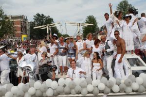 06-08-2009 SHOWBIZZ; GAY PRIDE AMSTERDAM TREKT MEER DAN 600.000 BEZOEKERS. Een giga festijn de 2009 Gay Pride in Amsterdam, duizenden bootjes, honderdduizenden bezoekers en een Sinterklaas die na het uur moest worden opgenomen met wel heel vreemde verschijnselen, en als wij de media moeten geloven na het drinken van een wodkaatje. Wij weten beter want wij waren er smorgens vroeg al bij,plaats van alle verrassingen De Westerdok haven.Toen was het nog niet heet, er waaide een heerlijk windje en de aanwezige BNers hadden er zin in, zelfs Sint Nicolaas of te wel Gordon. Menig drankje gleed naar binnen voordat de boten vertrokken richting de Prinsengracht. Als dat maar goed gaat dacht ik nog. En het ging niet goed, Sint Nicolaas werd witter dan wit en werd lieftallig verzorgd door de dames met ijsklontjes. Niks hitte beroerte of een schommelende boot, zware mijter of Sinterklaaspak van velours. Gordon droeg een wit katoenen pantalon en een katoenen hemt met inderdaad een mantel die helemaal los hing. Niks bevangen door de hitte, andere oorzaken dwongen hem tot stoppen van de Stoompoot boot. Sinterklaas werd afgevoerd in een ambulance voor verder onderzoek. Zondag avond was Gordon weer van de partij om de Gay Pride party te besluiten met een optreden. Al met al weer een zeer bewogen weekend voor vele mensen.
foto: Albert den Iseger