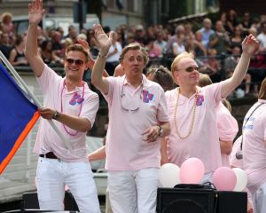 06-08-2009 SHOWBIZZ; GAY PRIDE AMSTERDAM TREKT MEER DAN 600.000 BEZOEKERS. Een giga festijn de 2009 Gay Pride in Amsterdam, duizenden bootjes, honderdduizenden bezoekers en een Sinterklaas die na het uur moest worden opgenomen met wel heel vreemde verschijnselen, en als wij de media moeten geloven na het drinken van een wodkaatje. Wij weten beter want wij waren er smorgens vroeg al bij,plaats van alle verrassingen De Westerdok haven.Toen was het nog niet heet, er waaide een heerlijk windje en de aanwezige BNers hadden er zin in, zelfs Sint Nicolaas of te wel Gordon. Menig drankje gleed naar binnen voordat de boten vertrokken richting de Prinsengracht. Als dat maar goed gaat dacht ik nog. En het ging niet goed, Sint Nicolaas werd witter dan wit en werd lieftallig verzorgd door de dames met ijsklontjes. Niks hitte beroerte of een schommelende boot, zware mijter of Sinterklaaspak van velours. Gordon droeg een wit katoenen pantalon en een katoenen hemt met inderdaad een mantel die helemaal los hing. Niks bevangen door de hitte, andere oorzaken dwongen hem tot stoppen van de Stoompoot boot. Sinterklaas werd afgevoerd in een ambulance voor verder onderzoek. Zondag avond was Gordon weer van de partij om de Gay Pride party te besluiten met een optreden. Al met al weer een zeer bewogen weekend voor vele mensen.
foto: Albert den Iseger