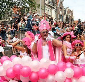 06-08-2009 SHOWBIZZ; GAY PRIDE AMSTERDAM TREKT MEER DAN 600.000 BEZOEKERS. Een giga festijn de 2009 Gay Pride in Amsterdam, duizenden bootjes, honderdduizenden bezoekers en een Sinterklaas die na het uur moest worden opgenomen met wel heel vreemde verschijnselen, en als wij de media moeten geloven na het drinken van een wodkaatje. Wij weten beter want wij waren er smorgens vroeg al bij,plaats van alle verrassingen De Westerdok haven.Toen was het nog niet heet, er waaide een heerlijk windje en de aanwezige BNers hadden er zin in, zelfs Sint Nicolaas of te wel Gordon. Menig drankje gleed naar binnen voordat de boten vertrokken richting de Prinsengracht. Als dat maar goed gaat dacht ik nog. En het ging niet goed, Sint Nicolaas werd witter dan wit en werd lieftallig verzorgd door de dames met ijsklontjes. Niks hitte beroerte of een schommelende boot, zware mijter of Sinterklaaspak van velours. Gordon droeg een wit katoenen pantalon en een katoenen hemt met inderdaad een mantel die helemaal los hing. Niks bevangen door de hitte, andere oorzaken dwongen hem tot stoppen van de Stoompoot boot. Sinterklaas werd afgevoerd in een ambulance voor verder onderzoek. Zondag avond was Gordon weer van de partij om de Gay Pride party te besluiten met een optreden. Al met al weer een zeer bewogen weekend voor vele mensen.
foto: Albert den Iseger