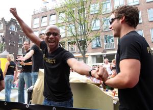 06-08-2009 SHOWBIZZ; GAY PRIDE AMSTERDAM TREKT MEER DAN 600.000 BEZOEKERS. Een giga festijn de 2009 Gay Pride in Amsterdam, duizenden bootjes, honderdduizenden bezoekers en een Sinterklaas die na het uur moest worden opgenomen met wel heel vreemde verschijnselen, en als wij de media moeten geloven na het drinken van een wodkaatje. Wij weten beter want wij waren er smorgens vroeg al bij,plaats van alle verrassingen De Westerdok haven.Toen was het nog niet heet, er waaide een heerlijk windje en de aanwezige BNers hadden er zin in, zelfs Sint Nicolaas of te wel Gordon. Menig drankje gleed naar binnen voordat de boten vertrokken richting de Prinsengracht. Als dat maar goed gaat dacht ik nog. En het ging niet goed, Sint Nicolaas werd witter dan wit en werd lieftallig verzorgd door de dames met ijsklontjes. Niks hitte beroerte of een schommelende boot, zware mijter of Sinterklaaspak van velours. Gordon droeg een wit katoenen pantalon en een katoenen hemt met inderdaad een mantel die helemaal los hing. Niks bevangen door de hitte, andere oorzaken dwongen hem tot stoppen van de Stoompoot boot. Sinterklaas werd afgevoerd in een ambulance voor verder onderzoek. Zondag avond was Gordon weer van de partij om de Gay Pride party te besluiten met een optreden. Al met al weer een zeer bewogen weekend voor vele mensen.
foto: Albert den Iseger