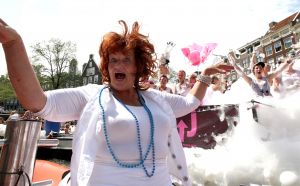 06-08-2009 SHOWBIZZ; GAY PRIDE AMSTERDAM TREKT MEER DAN 600.000 BEZOEKERS. Een giga festijn de 2009 Gay Pride in Amsterdam, duizenden bootjes, honderdduizenden bezoekers en een Sinterklaas die na het uur moest worden opgenomen met wel heel vreemde verschijnselen, en als wij de media moeten geloven na het drinken van een wodkaatje. Wij weten beter want wij waren er smorgens vroeg al bij,plaats van alle verrassingen De Westerdok haven.Toen was het nog niet heet, er waaide een heerlijk windje en de aanwezige BNers hadden er zin in, zelfs Sint Nicolaas of te wel Gordon. Menig drankje gleed naar binnen voordat de boten vertrokken richting de Prinsengracht. Als dat maar goed gaat dacht ik nog. En het ging niet goed, Sint Nicolaas werd witter dan wit en werd lieftallig verzorgd door de dames met ijsklontjes. Niks hitte beroerte of een schommelende boot, zware mijter of Sinterklaaspak van velours. Gordon droeg een wit katoenen pantalon en een katoenen hemt met inderdaad een mantel die helemaal los hing. Niks bevangen door de hitte, andere oorzaken dwongen hem tot stoppen van de Stoompoot boot. Sinterklaas werd afgevoerd in een ambulance voor verder onderzoek. Zondag avond was Gordon weer van de partij om de Gay Pride party te besluiten met een optreden. Al met al weer een zeer bewogen weekend voor vele mensen.
foto: Albert den Iseger