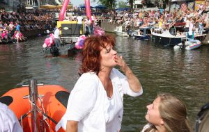 06-08-2009 SHOWBIZZ; GAY PRIDE AMSTERDAM TREKT MEER DAN 600.000 BEZOEKERS. Een giga festijn de 2009 Gay Pride in Amsterdam, duizenden bootjes, honderdduizenden bezoekers en een Sinterklaas die na het uur moest worden opgenomen met wel heel vreemde verschijnselen, en als wij de media moeten geloven na het drinken van een wodkaatje. Wij weten beter want wij waren er smorgens vroeg al bij,plaats van alle verrassingen De Westerdok haven.Toen was het nog niet heet, er waaide een heerlijk windje en de aanwezige BNers hadden er zin in, zelfs Sint Nicolaas of te wel Gordon. Menig drankje gleed naar binnen voordat de boten vertrokken richting de Prinsengracht. Als dat maar goed gaat dacht ik nog. En het ging niet goed, Sint Nicolaas werd witter dan wit en werd lieftallig verzorgd door de dames met ijsklontjes. Niks hitte beroerte of een schommelende boot, zware mijter of Sinterklaaspak van velours. Gordon droeg een wit katoenen pantalon en een katoenen hemt met inderdaad een mantel die helemaal los hing. Niks bevangen door de hitte, andere oorzaken dwongen hem tot stoppen van de Stoompoot boot. Sinterklaas werd afgevoerd in een ambulance voor verder onderzoek. Zondag avond was Gordon weer van de partij om de Gay Pride party te besluiten met een optreden. Al met al weer een zeer bewogen weekend voor vele mensen.
foto: Albert den Iseger
