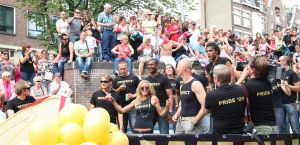06-08-2009 SHOWBIZZ; GAY PRIDE AMSTERDAM TREKT MEER DAN 600.000 BEZOEKERS. Een giga festijn de 2009 Gay Pride in Amsterdam, duizenden bootjes, honderdduizenden bezoekers en een Sinterklaas die na het uur moest worden opgenomen met wel heel vreemde verschijnselen, en als wij de media moeten geloven na het drinken van een wodkaatje. Wij weten beter want wij waren er smorgens vroeg al bij,plaats van alle verrassingen De Westerdok haven.Toen was het nog niet heet, er waaide een heerlijk windje en de aanwezige BNers hadden er zin in, zelfs Sint Nicolaas of te wel Gordon. Menig drankje gleed naar binnen voordat de boten vertrokken richting de Prinsengracht. Als dat maar goed gaat dacht ik nog. En het ging niet goed, Sint Nicolaas werd witter dan wit en werd lieftallig verzorgd door de dames met ijsklontjes. Niks hitte beroerte of een schommelende boot, zware mijter of Sinterklaaspak van velours. Gordon droeg een wit katoenen pantalon en een katoenen hemt met inderdaad een mantel die helemaal los hing. Niks bevangen door de hitte, andere oorzaken dwongen hem tot stoppen van de Stoompoot boot. Sinterklaas werd afgevoerd in een ambulance voor verder onderzoek. Zondag avond was Gordon weer van de partij om de Gay Pride party te besluiten met een optreden. Al met al weer een zeer bewogen weekend voor vele mensen.
foto: Albert den Iseger