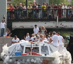 06-08-2009 SHOWBIZZ; GAY PRIDE AMSTERDAM TREKT MEER DAN 600.000 BEZOEKERS. Een giga festijn de 2009 Gay Pride in Amsterdam, duizenden bootjes, honderdduizenden bezoekers en een Sinterklaas die na het uur moest worden opgenomen met wel heel vreemde verschijnselen, en als wij de media moeten geloven na het drinken van een wodkaatje. Wij weten beter want wij waren er smorgens vroeg al bij,plaats van alle verrassingen De Westerdok haven.Toen was het nog niet heet, er waaide een heerlijk windje en de aanwezige BNers hadden er zin in, zelfs Sint Nicolaas of te wel Gordon. Menig drankje gleed naar binnen voordat de boten vertrokken richting de Prinsengracht. Als dat maar goed gaat dacht ik nog. En het ging niet goed, Sint Nicolaas werd witter dan wit en werd lieftallig verzorgd door de dames met ijsklontjes. Niks hitte beroerte of een schommelende boot, zware mijter of Sinterklaaspak van velours. Gordon droeg een wit katoenen pantalon en een katoenen hemt met inderdaad een mantel die helemaal los hing. Niks bevangen door de hitte, andere oorzaken dwongen hem tot stoppen van de Stoompoot boot. Sinterklaas werd afgevoerd in een ambulance voor verder onderzoek. Zondag avond was Gordon weer van de partij om de Gay Pride party te besluiten met een optreden. Al met al weer een zeer bewogen weekend voor vele mensen.
foto: Albert den Iseger