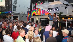 06-08-2009 SHOWBIZZ; GAY PRIDE AMSTERDAM TREKT MEER DAN 600.000 BEZOEKERS. Een giga festijn de 2009 Gay Pride in Amsterdam, duizenden bootjes, honderdduizenden bezoekers en een Sinterklaas die na het uur moest worden opgenomen met wel heel vreemde verschijnselen, en als wij de media moeten geloven na het drinken van een wodkaatje. Wij weten beter want wij waren er smorgens vroeg al bij,plaats van alle verrassingen De Westerdok haven.Toen was het nog niet heet, er waaide een heerlijk windje en de aanwezige BNers hadden er zin in, zelfs Sint Nicolaas of te wel Gordon. Menig drankje gleed naar binnen voordat de boten vertrokken richting de Prinsengracht. Als dat maar goed gaat dacht ik nog. En het ging niet goed, Sint Nicolaas werd witter dan wit en werd lieftallig verzorgd door de dames met ijsklontjes. Niks hitte beroerte of een schommelende boot, zware mijter of Sinterklaaspak van velours. Gordon droeg een wit katoenen pantalon en een katoenen hemt met inderdaad een mantel die helemaal los hing. Niks bevangen door de hitte, andere oorzaken dwongen hem tot stoppen van de Stoompoot boot. Sinterklaas werd afgevoerd in een ambulance voor verder onderzoek. Zondag avond was Gordon weer van de partij om de Gay Pride party te besluiten met een optreden. Al met al weer een zeer bewogen weekend voor vele mensen.
foto: Albert den Iseger