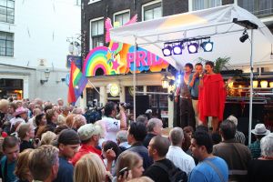 06-08-2009 SHOWBIZZ; GAY PRIDE AMSTERDAM TREKT MEER DAN 600.000 BEZOEKERS. Een giga festijn de 2009 Gay Pride in Amsterdam, duizenden bootjes, honderdduizenden bezoekers en een Sinterklaas die na het uur moest worden opgenomen met wel heel vreemde verschijnselen, en als wij de media moeten geloven na het drinken van een wodkaatje. Wij weten beter want wij waren er smorgens vroeg al bij,plaats van alle verrassingen De Westerdok haven.Toen was het nog niet heet, er waaide een heerlijk windje en de aanwezige BNers hadden er zin in, zelfs Sint Nicolaas of te wel Gordon. Menig drankje gleed naar binnen voordat de boten vertrokken richting de Prinsengracht. Als dat maar goed gaat dacht ik nog. En het ging niet goed, Sint Nicolaas werd witter dan wit en werd lieftallig verzorgd door de dames met ijsklontjes. Niks hitte beroerte of een schommelende boot, zware mijter of Sinterklaaspak van velours. Gordon droeg een wit katoenen pantalon en een katoenen hemt met inderdaad een mantel die helemaal los hing. Niks bevangen door de hitte, andere oorzaken dwongen hem tot stoppen van de Stoompoot boot. Sinterklaas werd afgevoerd in een ambulance voor verder onderzoek. Zondag avond was Gordon weer van de partij om de Gay Pride party te besluiten met een optreden. Al met al weer een zeer bewogen weekend voor vele mensen.
foto: Albert den Iseger