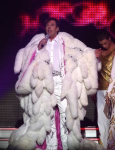 29-12-2007 SHOWBIZZ; CONCERT GERARD JOLING STOUT EN NIEUW 2007. Donderdag en Vrijdagavond was het weer een Joling feestje in de Ahoy. Dat Gerard zich thuis voelt in de Ahoy was direct te merken, de stemming zat er direct in na de eerste muzieknoten. De zanger was soms niet goed bij stem en moest het achtergrondkoortje het opvangen of Gerard liet het publiek zingen. Zijn vaak eigenzinnige grapjes waren meer dan eens op het randje en daar kan Dre Hazes van meepraten, zo vroeg Gerard aan Dre of ook alles lekker met hem meegroeide. Naast Dre Hazes trad ook Bonnie St.Clair op die opmerkelijk de tribunes deed schudden. Maaike en Tessa en Bearforce One deden hun eigen ding maar waren geen toevoeging tot de Joling Show. De knuffelberen van Bearforce One stonden volgens velen slecht te playbacken. De uitstraling van de show was niet echt Stout te noemen en had allemaal wat brutaler gemogen, ondanks de vele glitterpakken en veren jassen, daar maakt men de show niet Stout mee.De beloofde pikante en Stoute show heb ik niet gezien. Wel een echt Joling concert met een hoog Gaygehalte in het repertoire. Al met al was het een gezellig avondje uit voor de Joling fans al bestaan die voornamelijk uit Oma-s travestieten en studentes die in de pauze ook uit hun dak gingen toen de DJ een hit draaide van Frans Bauer.
foto: Albert den Iseger.