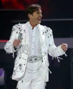 29-12-2007 SHOWBIZZ; CONCERT GERARD JOLING STOUT EN NIEUW 2007. Donderdag en Vrijdagavond was het weer een Joling feestje in de Ahoy. Dat Gerard zich thuis voelt in de Ahoy was direct te merken, de stemming zat er direct in na de eerste muzieknoten. De zanger was soms niet goed bij stem en moest het achtergrondkoortje het opvangen of Gerard liet het publiek zingen. Zijn vaak eigenzinnige grapjes waren meer dan eens op het randje en daar kan Dre Hazes van meepraten, zo vroeg Gerard aan Dre of ook alles lekker met hem meegroeide. Naast Dre Hazes trad ook Bonnie St.Clair op die opmerkelijk de tribunes deed schudden. Maaike en Tessa en Bearforce One deden hun eigen ding maar waren geen toevoeging tot de Joling Show. De knuffelberen van Bearforce One stonden volgens velen slecht te playbacken. De uitstraling van de show was niet echt Stout te noemen en had allemaal wat brutaler gemogen, ondanks de vele glitterpakken en veren jassen, daar maakt men de show niet Stout mee.De beloofde pikante en Stoute show heb ik niet gezien. Wel een echt Joling concert met een hoog Gaygehalte in het repertoire. Al met al was het een gezellig avondje uit voor de Joling fans al bestaan die voornamelijk uit Oma-s travestieten en studentes die in de pauze ook uit hun dak gingen toen de DJ een hit draaide van Frans Bauer.
foto: Albert den Iseger.