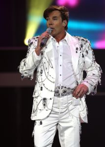 29-12-2007 SHOWBIZZ; CONCERT GERARD JOLING STOUT EN NIEUW 2007. Donderdag en Vrijdagavond was het weer een Joling feestje in de Ahoy. Dat Gerard zich thuis voelt in de Ahoy was direct te merken, de stemming zat er direct in na de eerste muzieknoten. De zanger was soms niet goed bij stem en moest het achtergrondkoortje het opvangen of Gerard liet het publiek zingen. Zijn vaak eigenzinnige grapjes waren meer dan eens op het randje en daar kan Dre Hazes van meepraten, zo vroeg Gerard aan Dre of ook alles lekker met hem meegroeide. Naast Dre Hazes trad ook Bonnie St.Clair op die opmerkelijk de tribunes deed schudden. Maaike en Tessa en Bearforce One deden hun eigen ding maar waren geen toevoeging tot de Joling Show. De knuffelberen van Bearforce One stonden volgens velen slecht te playbacken. De uitstraling van de show was niet echt Stout te noemen en had allemaal wat brutaler gemogen, ondanks de vele glitterpakken en veren jassen, daar maakt men de show niet Stout mee.De beloofde pikante en Stoute show heb ik niet gezien. Wel een echt Joling concert met een hoog Gaygehalte in het repertoire. Al met al was het een gezellig avondje uit voor de Joling fans al bestaan die voornamelijk uit Oma-s travestieten en studentes die in de pauze ook uit hun dak gingen toen de DJ een hit draaide van Frans Bauer.
foto: Albert den Iseger.