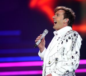29-12-2007 SHOWBIZZ; CONCERT GERARD JOLING STOUT EN NIEUW 2007. Donderdag en Vrijdagavond was het weer een Joling feestje in de Ahoy. Dat Gerard zich thuis voelt in de Ahoy was direct te merken, de stemming zat er direct in na de eerste muzieknoten. De zanger was soms niet goed bij stem en moest het achtergrondkoortje het opvangen of Gerard liet het publiek zingen. Zijn vaak eigenzinnige grapjes waren meer dan eens op het randje en daar kan Dre Hazes van meepraten, zo vroeg Gerard aan Dre of ook alles lekker met hem meegroeide. Naast Dre Hazes trad ook Bonnie St.Clair op die opmerkelijk de tribunes deed schudden. Maaike en Tessa en Bearforce One deden hun eigen ding maar waren geen toevoeging tot de Joling Show. De knuffelberen van Bearforce One stonden volgens velen slecht te playbacken. De uitstraling van de show was niet echt Stout te noemen en had allemaal wat brutaler gemogen, ondanks de vele glitterpakken en veren jassen, daar maakt men de show niet Stout mee.De beloofde pikante en Stoute show heb ik niet gezien. Wel een echt Joling concert met een hoog Gaygehalte in het repertoire. Al met al was het een gezellig avondje uit voor de Joling fans al bestaan die voornamelijk uit Oma-s travestieten en studentes die in de pauze ook uit hun dak gingen toen de DJ een hit draaide van Frans Bauer.
foto: Albert den Iseger.