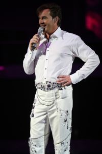 29-12-2007 SHOWBIZZ; CONCERT GERARD JOLING STOUT EN NIEUW 2007. Donderdag en Vrijdagavond was het weer een Joling feestje in de Ahoy. Dat Gerard zich thuis voelt in de Ahoy was direct te merken, de stemming zat er direct in na de eerste muzieknoten. De zanger was soms niet goed bij stem en moest het achtergrondkoortje het opvangen of Gerard liet het publiek zingen. Zijn vaak eigenzinnige grapjes waren meer dan eens op het randje en daar kan Dre Hazes van meepraten, zo vroeg Gerard aan Dre of ook alles lekker met hem meegroeide. Naast Dre Hazes trad ook Bonnie St.Clair op die opmerkelijk de tribunes deed schudden. Maaike en Tessa en Bearforce One deden hun eigen ding maar waren geen toevoeging tot de Joling Show. De knuffelberen van Bearforce One stonden volgens velen slecht te playbacken. De uitstraling van de show was niet echt Stout te noemen en had allemaal wat brutaler gemogen, ondanks de vele glitterpakken en veren jassen, daar maakt men de show niet Stout mee.De beloofde pikante en Stoute show heb ik niet gezien. Wel een echt Joling concert met een hoog Gaygehalte in het repertoire. Al met al was het een gezellig avondje uit voor de Joling fans al bestaan die voornamelijk uit Oma-s travestieten en studentes die in de pauze ook uit hun dak gingen toen de DJ een hit draaide van Frans Bauer.
foto: Albert den Iseger.