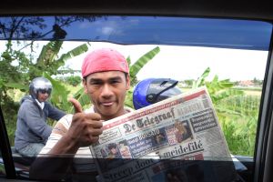 16-12-2009 NIEUWS: TELEGRAAF TE KOOP IN UBUD BALI. Bij het stoplicht wachten en dan in de haast de Telegraaf kopen van gisteren, ingeseald en wel. Na 5 euro betaald te hebben voor de krant van gisteren deed ik een niet leuke ontdekking nadat ik de gesealde krant open sloeg.Het was een Telegraaf van 29 September 2009.Ik had namelijk wel een data gezocht op de voorpagina maar die ontbrak.De openingsverhalen kwamen mij al wat vreemd over maar ja een krantje is toch wel even gezellig om op een Balinees terrasje te lezen.Ik moest naderhand wel lachen om de streek van die slimme jongens. Op de terug weg stonden ze er nog met diverse andere internationale kranten ook van oude data, maar wel mooi ingeseald. Gelukkig schoot ik het moment dat de jongen mij de krant aanbod nog even een foto.
foto: Albert den Iseger.