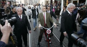 27-03-2007 SHOWBIZZ; ACTEUR ROWAN ATKINSON OF MR.BEAN WAS IN AMSTERDAM VOOR FILM PREMIERE. Maandagavond kwam Rowan Atkinson als zijn typetje Mr. Bean op de fiets naar de premiere van zijn nieuwste film. Hij reed van de Munt naar de Reguliersbreestraat en stapte af voor de deur van Tuschinki. Echter niet zonder problemen, vele fotografen, filmploegen  en bijzonder veel publiek zorgden hier en daar voor chaos, net als in zijn nieuwste film waar hij van Londen naar de Riviere reist. Bekend Nederland liet het massaal afweten, welgeteld waren er slechts 4 B ners komen opdagen.
Na de presentatie van de film sloop de komiek via de achterdeur naar buiten en werd vlug afgevoerd naar het Amstel hotel.
foto: Albert den Iseger.
