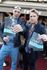 18-03-2012 SHOWBIZZ; SASKIA NOORT OVERHANDIGD EERSTE BOEK AAN JEUGDVRIEND RON MORET. Het boek met de titel SCHAAMSTREEK. Tekst is van de FLESSENPOST.
Schaamstreek, oesters en een koffie zet apparaat

Gistermiddag was het zo ver. De al eerder in het flesje aangekondigde presentatie van het boek de  Schaamstreek van schrijver Vincent Bakker bij restaurant Fabels vond plaats. De Bergense bestseller schrijfster Saskia Noort was uitgenodigd om het feestje op te leuken.
Ook de in deze contreien beroemde oesterkoning was aangekondigd, maar liet helaas verstek gaan. ondanks deze tegenslag vloeide de alcoholische drankjes rijkelijk. De Bergense kunstenaar Ron Moret staat centraal in het boek evenals de kunst10daagse 2011 en de Bergense kunst scene in zijn geheel. Saskia Noort hielt een warm, gloedvol en humoristisch betoog over het schrijfsel en Moret in het bijzonder. Het is slim en geniaal tegelijkertijd om daar eens een boekje over te schrijven, want ook landelijk wil men natuurlijk wel eens weten, wat er zich afspeelt in het sodom en gomora -bijgenaamd de Heerlijkheid- achter de duinen. 
Jammer is wel dat de schrijver zich blijkbaar niet realiseerde dat hij na de professionele presentatie van Noort er beter het zwijgen toe kan doen. En in plaats van wat onhoorbaar gemompel in een slecht afgestelde microfoon, eigenlijk alleen maar luidkeels hoeft te roepen, de Schaamstreek is bij alle Bergense boekhandels verkrijgbaar. maar alla de presentatie werd druk bezocht door een ieder die vindt dat hij tot de kunst scene behoord en natuurlijk ook die gene die hopen daar ooit toe kunnen behoren. En zelfs als dat laatste onmogelijk blijkt, dan is de iets te louwen kosteloos verkrijgbare bubbel toch altijd nog genoeg reden om aanwezig te zijn.
Als u nu denk, hoogste tijd om mezelf nu ook eindelijk eens op te dringen aan BB ers of BNers geen paniek, want u kunt op 21 maart a.s.  als ik het goed heb  met Saskia Noort aan tafel zitten samen met de schrijver Kluun bij ster restaurant Merlet. U kunt dan lunchen en twitteren voor het goede  iets met niet werkende spieren, naar ik me meen te herinneren  doel. Dus doe eens gek een prik met uw vorkje een sterretje weg. U kunt ook s-avond met  Michelin inspecteur  zanger Dries Roelvink aanschuiven, maar ik persoonlijk kies toch liever voor de lunch.
Verder Nog meer belangwekkend nieuws, want na lang wachten heeft niet alleen de Lamoraal een nieuwe handdoek automaat gekregen, maar na iets minder lang aandringen werd via een persbericht kenbaar gemaakt dat paviljoen  Uit de Kunst  een nieuw koffie zet apparaat heeft aangeschaft. Kortom wie beweert dat de horeca niet innovatief is heeft het mis. er gebeurt veel, heel veel
Op 31 maart a.s. daal bij Noord de afgang af, wandel een kwartier richting  de Kerf  en strijk neer bij een van de meest relaxte plekjes langs de Noordzeekust. Dan bestel ik een koffie  uit het nieuwe apparaat
  en ga eens lekker een uurtje  achet glas  over de Noordzee uit staren en over mijn zonden nadenken.., terwijl ik het net gedrukte en nu verkrijgbare boek 30 jaar Sissy-boy doorblader en denk wat een heerlijk schaamteloos dorp.
foto: Albert den Iseger
