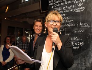 18-03-2012 SHOWBIZZ; SASKIA NOORT OVERHANDIGD EERSTE BOEK AAN JEUGDVRIEND RON MORET. Het boek met de titel SCHAAMSTREEK. Tekst is van de FLESSENPOST.
Schaamstreek, oesters en een koffie zet apparaat

Gistermiddag was het zo ver. De al eerder in het flesje aangekondigde presentatie van het boek de  Schaamstreek van schrijver Vincent Bakker bij restaurant Fabels vond plaats. De Bergense bestseller schrijfster Saskia Noort was uitgenodigd om het feestje op te leuken.
Ook de in deze contreien beroemde oesterkoning was aangekondigd, maar liet helaas verstek gaan. ondanks deze tegenslag vloeide de alcoholische drankjes rijkelijk. De Bergense kunstenaar Ron Moret staat centraal in het boek evenals de kunst10daagse 2011 en de Bergense kunst scene in zijn geheel. Saskia Noort hielt een warm, gloedvol en humoristisch betoog over het schrijfsel en Moret in het bijzonder. Het is slim en geniaal tegelijkertijd om daar eens een boekje over te schrijven, want ook landelijk wil men natuurlijk wel eens weten, wat er zich afspeelt in het sodom en gomora -bijgenaamd de Heerlijkheid- achter de duinen. 
Jammer is wel dat de schrijver zich blijkbaar niet realiseerde dat hij na de professionele presentatie van Noort er beter het zwijgen toe kan doen. En in plaats van wat onhoorbaar gemompel in een slecht afgestelde microfoon, eigenlijk alleen maar luidkeels hoeft te roepen, de Schaamstreek is bij alle Bergense boekhandels verkrijgbaar. maar alla de presentatie werd druk bezocht door een ieder die vindt dat hij tot de kunst scene behoord en natuurlijk ook die gene die hopen daar ooit toe kunnen behoren. En zelfs als dat laatste onmogelijk blijkt, dan is de iets te louwen kosteloos verkrijgbare bubbel toch altijd nog genoeg reden om aanwezig te zijn.
Als u nu denk, hoogste tijd om mezelf nu ook eindelijk eens op te dringen aan BB ers of BNers geen paniek, want u kunt op 21 maart a.s.  als ik het goed heb  met Saskia Noort aan tafel zitten samen met de schrijver Kluun bij ster restaurant Merlet. U kunt dan lunchen en twitteren voor het goede  iets met niet werkende spieren, naar ik me meen te herinneren  doel. Dus doe eens gek een prik met uw vorkje een sterretje weg. U kunt ook s-avond met  Michelin inspecteur  zanger Dries Roelvink aanschuiven, maar ik persoonlijk kies toch liever voor de lunch.
Verder Nog meer belangwekkend nieuws, want na lang wachten heeft niet alleen de Lamoraal een nieuwe handdoek automaat gekregen, maar na iets minder lang aandringen werd via een persbericht kenbaar gemaakt dat paviljoen  Uit de Kunst  een nieuw koffie zet apparaat heeft aangeschaft. Kortom wie beweert dat de horeca niet innovatief is heeft het mis. er gebeurt veel, heel veel
Op 31 maart a.s. daal bij Noord de afgang af, wandel een kwartier richting  de Kerf  en strijk neer bij een van de meest relaxte plekjes langs de Noordzeekust. Dan bestel ik een koffie  uit het nieuwe apparaat
  en ga eens lekker een uurtje  achet glas  over de Noordzee uit staren en over mijn zonden nadenken.., terwijl ik het net gedrukte en nu verkrijgbare boek 30 jaar Sissy-boy doorblader en denk wat een heerlijk schaamteloos dorp.
foto: Albert den Iseger
