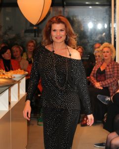31-03-2013 SHOWBIZZ; SHEILA DE VRIES GEEFT EXCLUSIEVE AVONDSHOW. AMSTERDAM - Het is akelig koud de hele week. Een snijdende wind, constateerde fashiondesigner Sheila De Vries die een exclusieve avondshow geeft voor haar klanten in haar winkel Sheila & Gideon Collections in de Cornelis Schuytstraat. Maar ondanks het ijskoude weer presenteren wij vanavond toch veel lange luchtige zomerjurken met een lage rug. Sheila De Vries werd onder meer bekend door de prachtige couture die zij ontwerpt voor Koningin Beatrix. Iedereen wacht met spanning op De Jurk van 30 april. Maar vanavond wordt haar show gepresenteerd door ... de actrices van Purper.
Zij laten in haar winkel in de hoofdstad haar nieuwe collectie zien. Met veel lange jurken en kaftans voor iedere maat en figuur. Van slankmakende voile en kantachtige materialen. Sheila reist de hele wereld af voor deze unieke stoffen waarvan zij zeer verschillende creaties maakt. Deze keer adviseert zij haar klanten voor de zomer altijd iets van zwart en wit in de kast te hebben. En dat mag ook best in een dessin zijn uitgevoerd.
Sheila maakt prachtige feelgood-jurken die iedere vrouw zowel op een gala als op een avond thuis fasntastisch staan. Jasjes met een meesterlijk dessin, bijzondere tassen, schoenen en sieraden naar eigen ontwerp. En Gideon toont markante jacks voor de moderne man. 
Alle actrices van Purper hebben hun eigen onnavolgbare manier om de creaties van Sheila aan de klanten te tonen. De markante verschijning van Gerrie Van der Klei is onvergetelijk als zij tijdens haar ronde in een lange krijtwitte en rechte jurk van opengewerkt materiaal vol waardigheid met een grote donkere bril op snel een slokje uit een glas wijn gapt. Zoiets zul je een echte mannequin nooit zien doen. Celine Purcell met haar grappige uitstraling is eenvoudig zichzelf.
Ook de blonde Mylou Frencken maakt tijdens deze show wat vrolijke danspassen die herinneren aan de Zumba van de sportschool. Enkele van de klanten van Sheila vertellen mij tijdens de afterparty deze show zo waarderen omdat hier nu eens dames met echte rondingen te zien zijn die ieder hun eigen stijl hebben... Dat klopt want de mysterieuze gratie van professionele mannequins is echt een vak apart. Toch weet Sheila s muze Anouk Van Nes als getraind danseres in een lange zwarte galajurk deze stijl met haar bijzondere flair goed te presenteren.
Het publiek houdt af en toe de adem in bij deze bijzondere Purper-presentatie. Maar hoe verrassend is dit theaterseizoen waar in plaats van vier heren in rokkostuum nu eens een groep van vier vrouwen in rok op de buhne als Purper optreedt. Vier dames die van wanten weten! De Purper Ladies zijn Gerrie Van der Klei, Anouk Van Nes, Celine Purcell en Mylou Frencken.
Vier vakvrouwen ook die hun sporen in het theater ruimschoots hebben verdiend en garant staan voor topkwaliteit, passend bij de Purper traditie. Een traditie die zich in het komend seizoen zal vernieuwen en verdiepen. Vrouwen van verschillende leeftijd en achtergrond die het publiek een avondlang zinnig entertainen. Vrouwen met lef, gein en geweldige stemmen. Het moet een Purper op haar best worden. Uniek. Als genre op zich, niet te imiteren.
Thema: Hoe staan vrouwen van verschillende leeftijden vandaag de dag in het leven? Een onderwerp dat met een gezonde dosis zelfspot tot een hilarische theateravond zal leiden. 
Fasten your seatbelts: de Purper Ladies komen eraan! Het wordt een heerlijk avondje uit!
foto: Albert den Iseger.