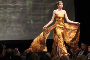 11-03-2014 SHOWBIZZ; ADDY VAN DEN KROMMENACKER PRESENTEERT VIAGGIO A VENEZIA Enkele dagen geleden kregen wij de uitnodiging of we bij de modeshow van Addy van den Krommenacker aanwezig wilden zijn. Wie kan daar nu  nee tegen zeggen. Dinsdag was eindelijk de grote dag!
Journalisten, modeliefhebbers, familie en goede vrienden van de Brabantse ontwerper betraden het Muziekgebouw aan t IJ in Amsterdam en natuurlijk was iedereen stijlvol gekleed. Tijdens de show, genaamd Viaggio a Venezia, liet ADDY drie van zijn nieuwe collecties zien: de zomer pret-a-porter lijn, winter pret-a-porter lijn en zijn couturecollectie.

Addy heeft zich voor zijn nieuwe collecties geheel laten inspireren door zijn grote liefde voor Italie. Voor de zomercollectie komen de invloeden rechtstreeks uit de badplaats Santa Margherita, waarbij blauw en wit met elkaar worden afgewisseld in zowel zwierige als zakelijke looks. De winterlijn laat de bekende stad Venetie eruit springen met donkere tinten en een mooie Italiaanse print.

De couturecollectie laat het nachtleven van het bruisende Italie zien. Diverse nudetinten en poederkleuren komen voorbij in de meest vrouwelijke jurken, waarvan iedere vrouw droomt. Strapless wordt afgewisseld met een split en rijkelijke glanzende stoffen met pailletten en veren. De laatste ronde betreft een gemaskerd bal met veel borduursels, tule en kant wat de ontwerpen een zeer romantische, sprookjesachtige en vrouwelijke uitstraling geeft. Oja, en laten we het topstuk van de avond, de bruidsjurk, niet vergeten! Wauw, wauw en nog eens wauw
foto: Albert den Iseger
